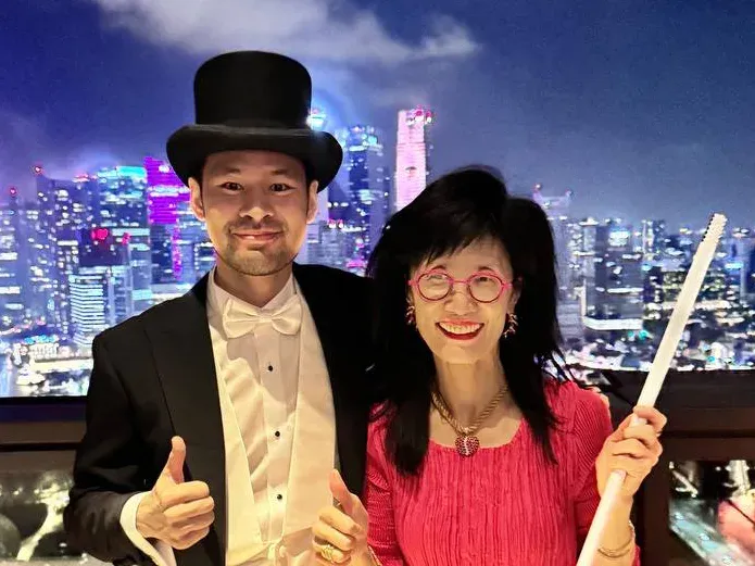 Linus in a top hat with Dr Hwang Yee Cheau above the city skyline on New Year's Eve